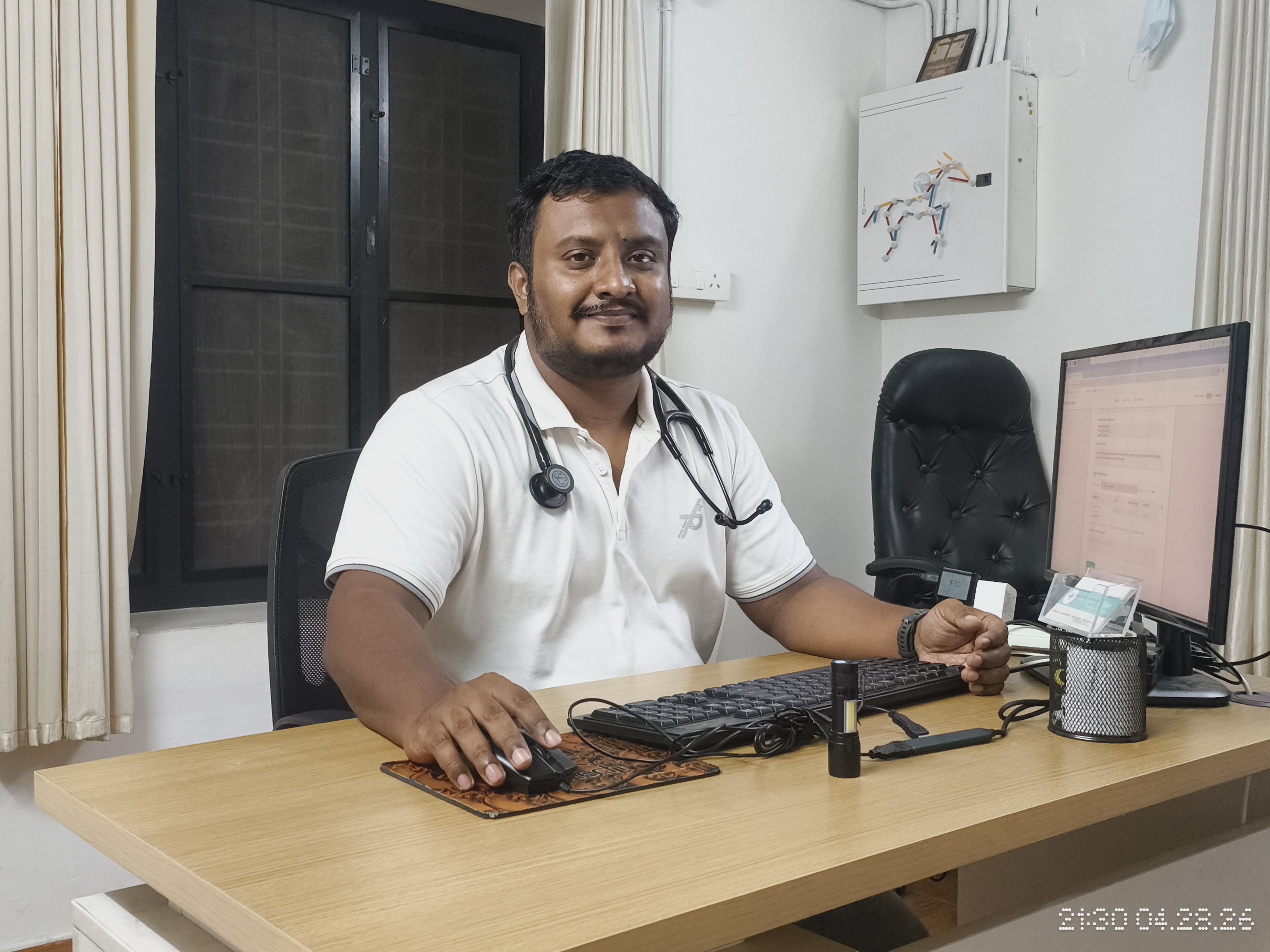 Dr. Peter Prince Pokkattu, Internal Medicine Physician, at his consulting desk in Thripunithura, Kochi